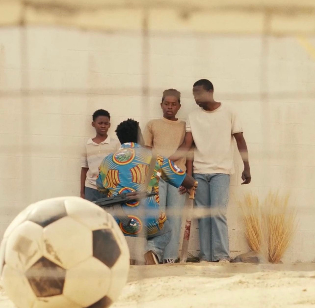 Scene still with a soccer ball in the foreground