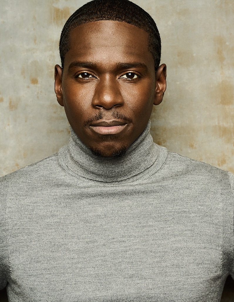 Maurice Mack, close-up headshot in a grey turtleneck